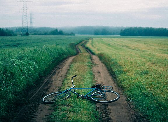 Ein Fahrrad liegt auf einem Feldweg