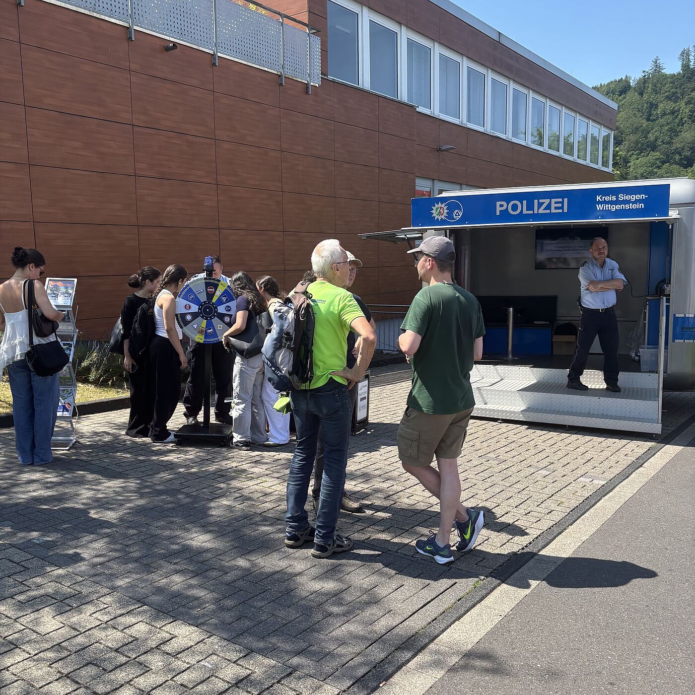 Infostand Polizei Am Infostand der Polizei in Siegen-Eiserfeld informiert sich eine Gruppe Schüler:innen über Radverkehrssicherheit.