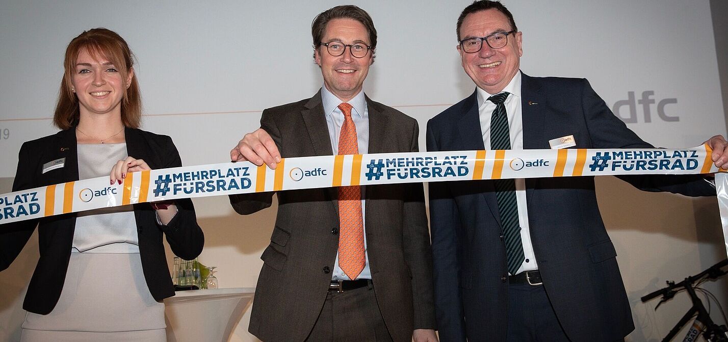 Bundesverkehrsminister Andreas Scheuer beim ADFC-Symposium #MehrPlatzFürsRad Bundesverkehrsminister Scheuer (m.) eröffnete das Symposium #MehrPlatzFürsRad zum 40-jährigen Bestehen des ADFC. Mit im Bild: Rebecca Peters, stv. ADFC-Bundesvorsitzende (l.) und Ulrich Syberg, ADFC-Bundesvorsitzender.