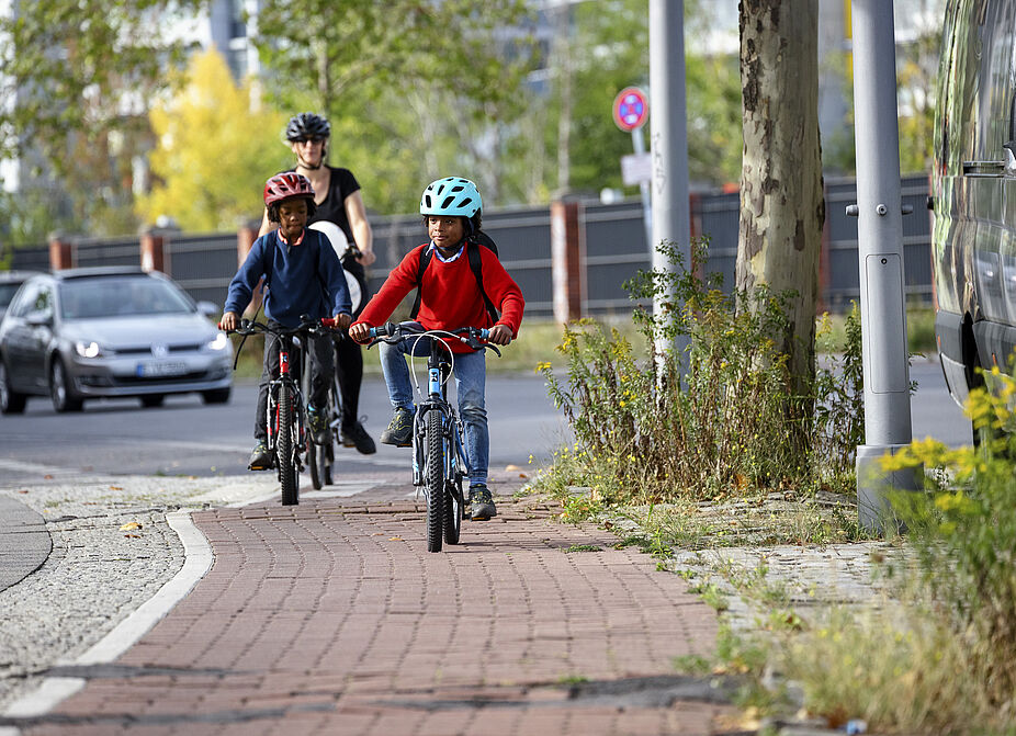Gemeinsam mit dem Fahrrad unterwegs Zwei Kinder auf dem Radweg