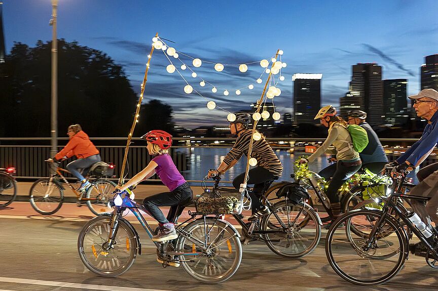 ADFC bike-night Frankfurt Radfahrenden mit beleuchteten Rädern in der Dämmerung